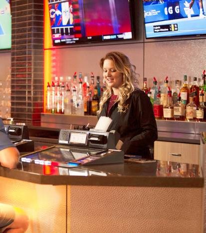Casino bartender serving gamblers at the bar.